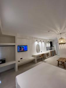 佩基罗德培福克斯蓝色公寓式酒店的一间白色卧室,配有床和电视