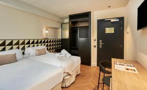 巴塞罗那The Moods Oasis的酒店客房设有两张床和一张桌子。