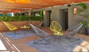 巴塞罗那The Moods Oasis的庭院里摆放着几把椅子和桌子