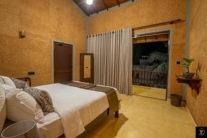 贝鲁沃勒Anura's Elephant的一间卧室设有一张床和一个滑动玻璃门