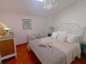 马尔旺A Casa Pequenina - Escusa, Marvão的卧室配有白色的床和吊灯。