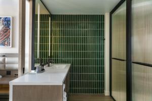 纳什维尔W Nashville的一间带水槽和绿色瓷砖墙的浴室