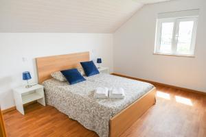 蓬德利马Casa Vilar的白色卧室配有一张带蓝色枕头的大床