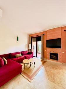 马拉喀什Pavillon Affaoui Golf & Waky的客厅设有红色的沙发和壁炉