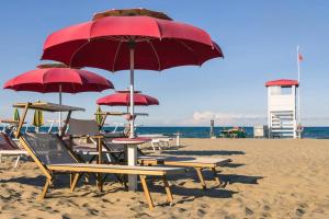 托雷德尔格拉戈普奇Cirilla Beach STUDIO apartment的海滩上的一组椅子和遮阳伞
