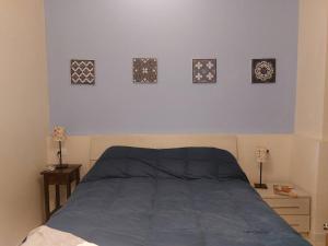 托雷德尔格拉戈普奇Cirilla Beach STUDIO apartment的卧室配有一张四幅画的墙壁床。