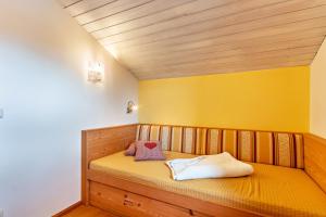WackersbergFerienwohnung Geierstein的一张小床,位于一个黄色墙壁的房间