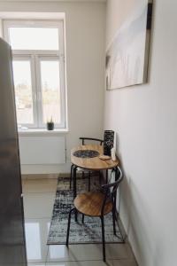 海乌姆Studio Centrum的客房设有桌子、两把椅子和窗户。