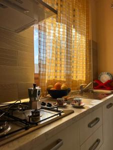 米内尔维诺迪莱切齐奥西西住宿加早餐旅馆的厨房配有炉灶和一碗水果
