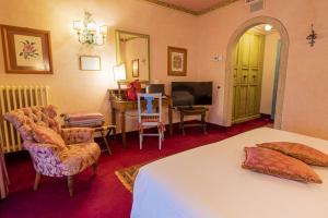 卡尔奇纳亚薄伽丘酒店的一间卧室配有一张床、一张书桌和一台电视