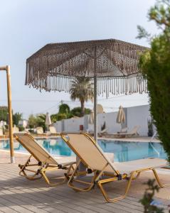 法里拉基Casa Blue Sarantis的游泳池旁的一对椅子和一把遮阳伞