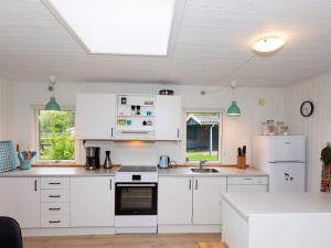 ØsløsHoliday home Vesløs IV的厨房配有白色橱柜和炉灶烤箱。