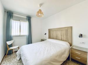 奇皮奥纳圣容旅游公寓的卧室配有一张白色大床和一把椅子