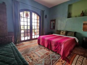 丹吉尔Hajrienne guest house的一间卧室设有一张床和一个大窗户