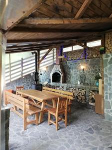 锡纳亚Casa Din Padure的一间设有木桌和石墙的用餐室