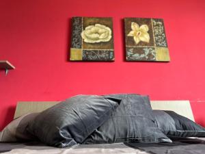 夸尔图-圣埃莱娜EM Holiday Apartment 3的一张红色墙上有两张照片的床