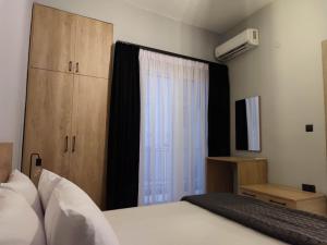 亚历山德鲁波利斯Mary's Apartment的一间卧室设有一张床和一个带键盘的窗户
