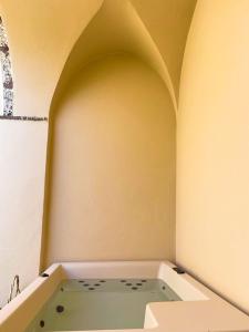 皮尔戈斯AENAON ESTATE 1896 by K&K的浴缸位于带拱门的房间