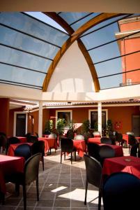 蒙泰罗通多星星酒店的餐厅设有红色的桌椅和玻璃天花板