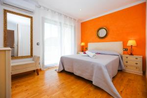萨洛Mediterranea Planet Costa Dorada的一间卧室设有橙色的墙壁、一张床和镜子