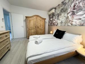加尔达Sunset Lodge的卧室配有一张大床,墙上挂有绘画作品