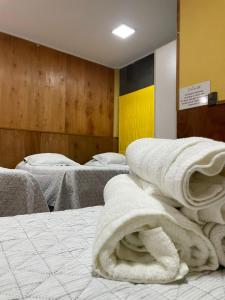 蒙特港Hotel Costa del Mar的一间设有三张床的房间,配有白色毛巾