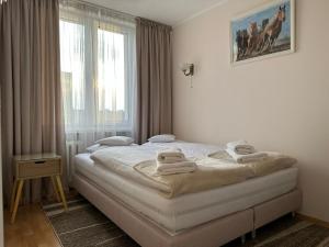 华沙Apartament Bazyliańska - 100m do Metra "Bródno", 20 minut do centrum Warszawy的一间卧室配有带毛巾的床