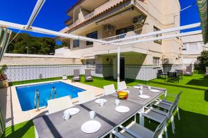 萨洛Mediterranea Planet Costa Dorada的一个带桌椅的庭院和一个游泳池