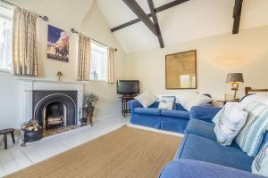 布兰克斯特Grooms Cottage B的客厅设有蓝色的沙发和壁炉