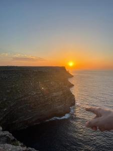 兰佩杜萨GC Petit Palais Lampedusa的日落时分在海洋上的人