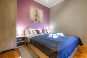 苏博蒂察DuMalux Velvet的一间卧室设有一张紫色墙壁的大床