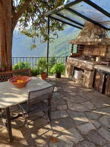 基索斯Orizontas Pilio Villa的石头庭院设有桌子和石头壁炉