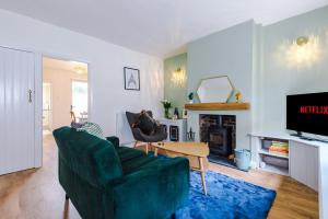 切斯特Pyecroft Cottage的客厅设有绿色沙发和壁炉