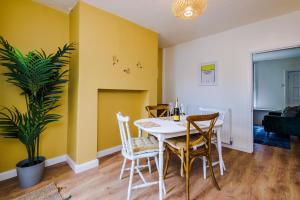 切斯特Pyecroft Cottage的用餐室设有黄色的墙壁和桌椅