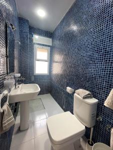 迈尔提勒HOSTAL MH BORJ的蓝色瓷砖浴室设有卫生间和水槽