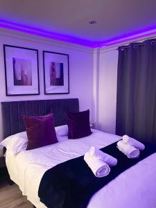 伦敦Stylish En Suite double room Kensington的一间卧室配有一张紫色照明的大床