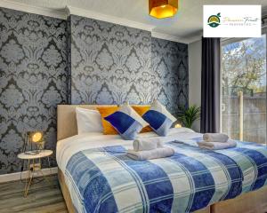 考文垂4 Bedroom House - Sleeps 7 Located Near Coventry Airport, City Centre, Free Unli Wi-fi - Driveway & Garden - AHC的一间卧室配有一张带蓝白色毯子的床