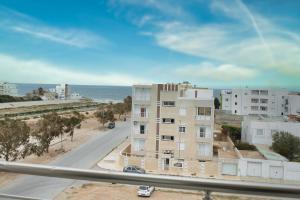 苏塞The Pearl Apartment Hammam Sousse WIFI的享有街道和大海的建筑景致