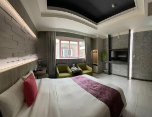 三峡爱莉亚汽车旅馆的酒店客房,配有一张床和两把椅子