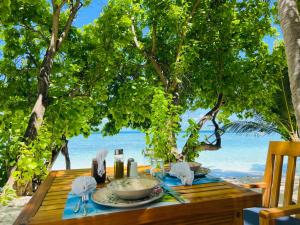 ThinadhooRISING SUN BEACH VIEW的海滩上的一张桌子和一碗食物