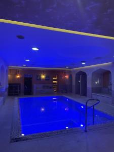 敖德萨守护神酒店的一座拥有蓝色天花板的大型游泳池