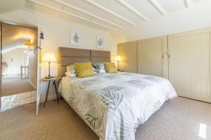 DersinghamSwift Cottage的一间卧室配有一张带黄色枕头的大床