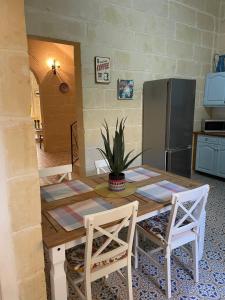 Taʼ AbramVilla Vella - 2 Bedroom House Gozo的厨房配有木桌和冰箱。