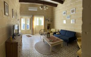 Taʼ AbramVilla Vella - 2 Bedroom House Gozo的客厅配有蓝色的沙发和桌子