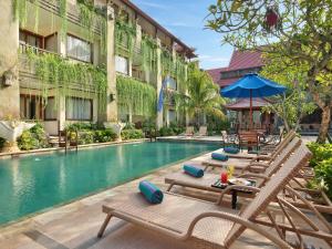 努沙杜瓦豪华巴厘岛努沙杜瓦酒店的一个带躺椅的游泳池和一间酒店