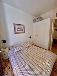 波尔特沃Apartamento Tramuntana de Portbou的一间卧室配有一张带条纹毯子的大床