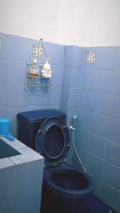 SentoolSinggah Macanan的蓝色的浴室设有黑色的厕所和水槽