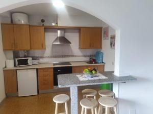 佩德罗佐Apartamentos turísticos Lemos的厨房配有木制橱柜和带凳子的台面