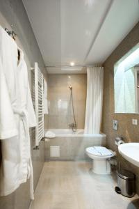 敖德萨守护神酒店的带浴缸、卫生间和盥洗盆的浴室