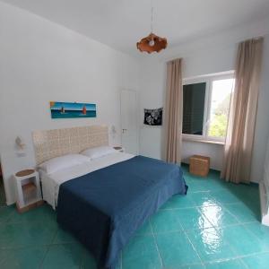 卡普里Villa del Sole的一间卧室配有一张床,铺有蓝色地板